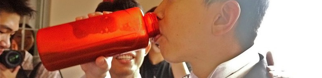 800px-Groom_drinking_from_bottle_during_Chinese_wedding_door_game