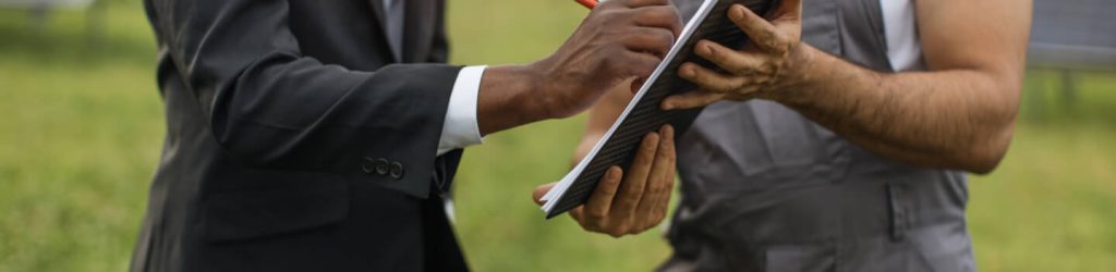 close-up-of-african-man-in-suit-signing-documents-on-clipboard